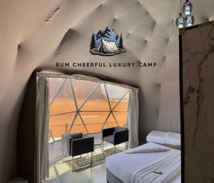 ワディ・ラムにあるRUM CHEERFUL lUXURY CAMPのベッドと椅子、窓が備わる客室です。