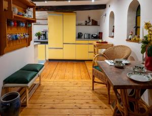 a kitchen with yellow cabinets and a table and chairs at Ferienwohnungen - Karin Kehne -Gartenblick in Bodenwerder