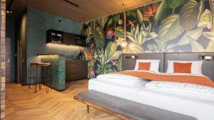 ein Schlafzimmer mit einem großen Bett mit Wandgemälde in der Unterkunft Hotel Sentio in Vöhringen