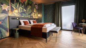 - une chambre avec un grand lit et une peinture murale dans l'établissement Hotel Sentio, à Vöhringen