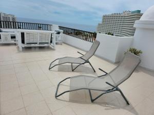 2 Stühle auf einem Balkon mit Meerblick im Hintergrund in der Unterkunft Luxury Penthouse Sea View Jacuzzy & pool wiffi free in Playa Fañabe