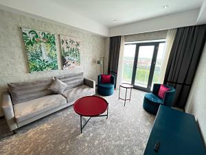 a living room with a couch and a table and chairs at Arena Grand Hotel in Quba