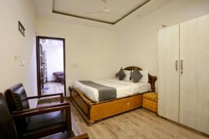 a bedroom with a bed and a sliding glass door at Hotel Shillo Nizamuddin in New Delhi
