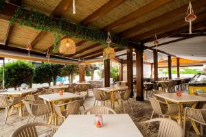 un restaurant en plein air avec des tables, des chaises et des lumières dans l'établissement Hostal Mar y Huerta, à Es Cana