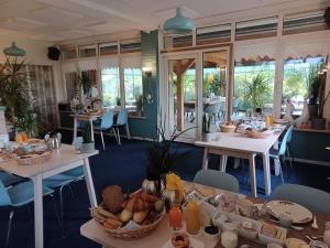 una habitación con mesas y sillas con comida. en Hotel Dichtbijzee en Oosterend