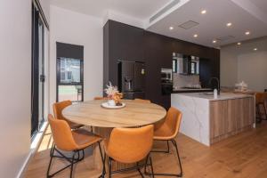 a kitchen and dining room with a wooden table and chairs at Entire House in Port Melbourne w Parking & Pool in Melbourne