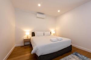 a bedroom with a bed with two towels on it at Entire House in Port Melbourne w Parking & Pool in Melbourne