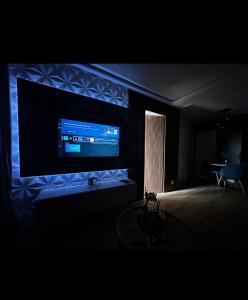 Camera oscura con una grande TV a parete di Appartement Louvres Premium - Roissy CDG a Louvres