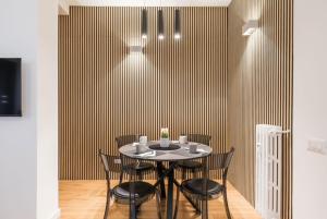 una sala da pranzo con tavolo e sedie neri di THE FIFTH Properties a Roma