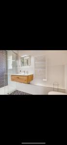 bagno con lavandino e specchio di Appartement Louvres Premium - Roissy CDG a Louvres