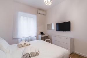 una camera da letto bianca con un letto e una TV a schermo piatto di THE FIFTH Properties a Roma