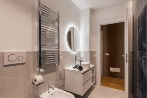 un bagno bianco con lavandino e specchio di THE FIFTH Properties a Roma