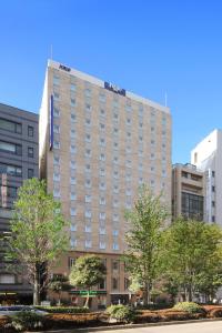 a tall building with a sign on top of it at Keio Presso Inn Ikebukuro in Tokyo