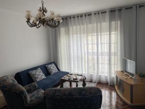 a living room with a couch and chairs and a window at Piso O Percebe in Muxia