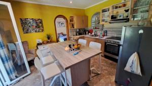 cocina con mesa de madera y nevera en 3 bedroom house w/private pool, en Astrakeri