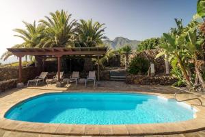 a pool in a yard with chairs and a gazebo at Finca Esperanza mit Privatpool, Whirlpool & Sauna in El Paso
