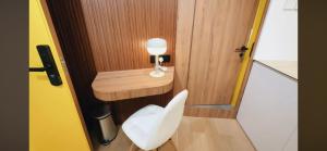uma pequena casa de banho com uma cadeira branca e uma secretária em Serenity Suite em Singapura