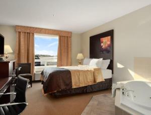 ein Hotelzimmer mit einem Bett und einem Bad in der Unterkunft Super 8 by Wyndham Innisfail in Innisfail