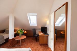 Habitación de hotel con cama, escritorio y espejo. en Hotel Garden Bremen en Bremen