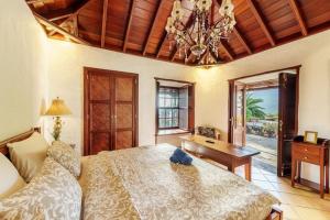 a bedroom with a bed and a desk and a chandelier at Finca Esperanza mit Privatpool, Whirlpool & Sauna in El Paso
