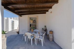 a dining room with a table and chairs on a patio at Ape Ermy in Avola