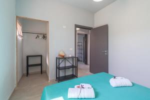 a bedroom with a blue bed with towels on it at Ape Ermy in Avola