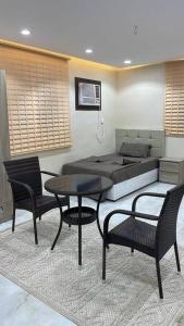 1 dormitorio con 1 cama, mesa y sillas en شقة ريم الوجة, en Al Wajh