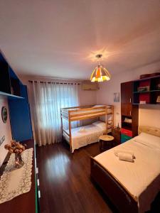 - une chambre avec 2 lits et un lustre dans l'établissement Nick Apartments, à Gjirokastër