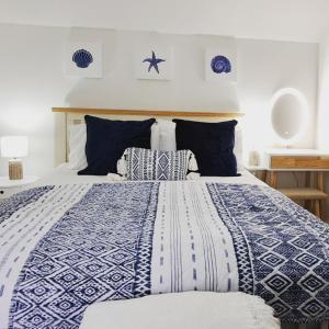 a bedroom with a blue and white bed with pillows at Cliff Cottage in Valtos