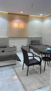 a bedroom with a bed and a chair and a table at شقة ريم الوجة in Al Wajh
