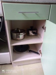 a kitchen cabinet with two pots and pans in it at Lillijas iela 5 can stay Free parking Park in Rīga