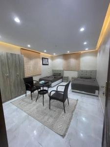 a living room with a bed and a table and chairs at شقة ريم الوجة in Al Wajh