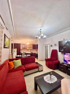 - un salon avec un canapé rouge et des fauteuils rouges dans l'établissement Nick Apartments, à Gjirokastër