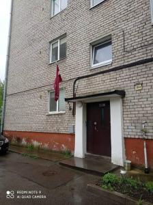 un bâtiment en briques avec une porte et un drapeau rouge dans l'établissement Lillijas iela 5 can stay Free parking Park, à Riga