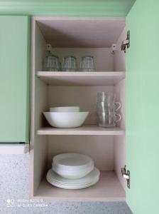 a cupboard with plates and dishes in a kitchen at Lillijas iela 5 can stay Free parking Park in Rīga