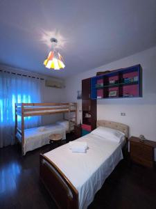- une chambre avec deux lits et une lumière dans l'établissement Nick Apartments, à Gjirokastër