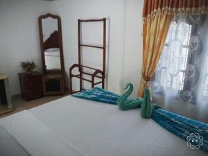 Una habitación con una cama con un cisne falso. en Tharindu Villa en Dankotuwa