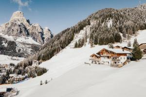 un lodge de esquí en una montaña cubierta de nieve en Refugium LaFlu Apartments, en Corvara in Badia