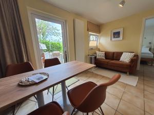 a living room with a wooden table and chairs at Haus Achtern Diek in erster Reihe am Meer in Fehmarn