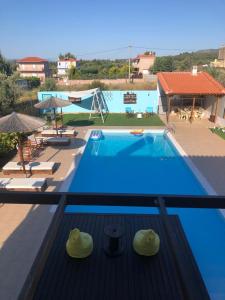 balcone con vista sulla piscina di un hotel di Villa Evenik a Eretria