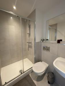 a bathroom with a shower and a toilet and a sink at Bright & Spacious Flat In London in Croydon