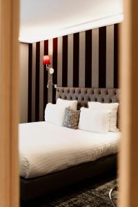 Hôtel Dali Val d'Europe في شانتيلو أو بْري: غرفة نوم مع سرير مع اللوح الأمامي الأسود والأبيض