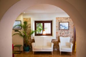 a living room with two chairs and a window at Hostal Mar y Huerta in Es Cana