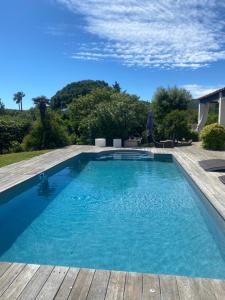 una piscina con terraza de madera y agua azul en Villa 55, en Grimaud