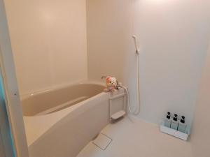 a bath tub with a stuffed animal sitting on the side of it at SECRET BASE Station Side in Osaka