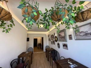 a dining room with tables and plants on the ceiling at Vila Fatos Qama in Berat