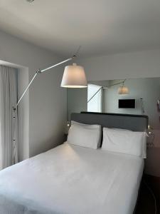 a bedroom with a white bed with two pillows at Hotel Miramare - Adults Only in Trieste