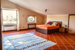 een slaapkamer met een bed en een klok aan de muur bij Angolo Paradiso - Casa vacanze sui campi da golf in Fubine