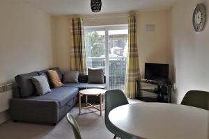 a living room with a couch and a table at Broad Gauge Apartments in Wolverhampton