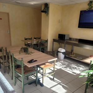 comedor con mesas y sillas y TV en Hôtel de l'Orb, en Bédarieux